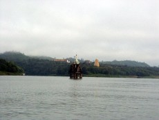Das was vom Glockenturm des Wat Sam Phrasop im September 2005 noch über Wasser ragte, im Hintergrund der goldene Prang des Wat Wangwiwakaram und der allgegenwärtige Morgennebel über der Stadt.
